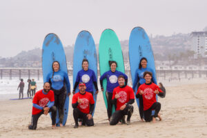 Group of students posing on the sand after the surf lesson